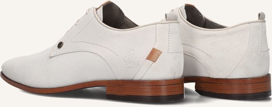 Zij-aanzicht van witte veterschoenen met bruine zool.