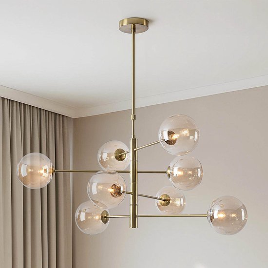 Gouden plafondlamp met 8 amberkleurige glazen bollen, gemonteerd in een woonkamer.