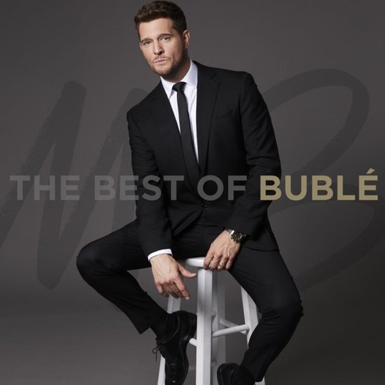Michael Bublé in zwart pak met stropdas, zittend op een witte kruk. "The Best of Bublé" staat op de achtergrond.