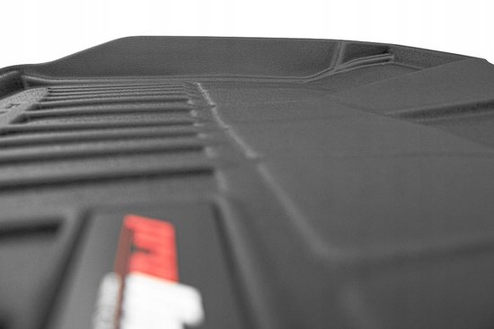 Extreme close-up van de textuur van een zwarte Proline 3D-vloermat met een deel van het logo.