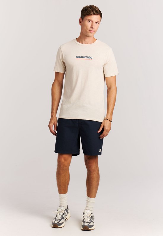 Man in zandkleurig t-shirt met 'PROTEST&CO' opdruk en marineblauwe korte broek.