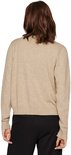 Een vrouw met bruin haar, rug naar de camera, draagt een beige gebreid vest met lange mouwen en zwarte broek.