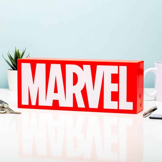 Marvel logo licht, rood met witte letters, op een bureau met kantoorspullen en plant.