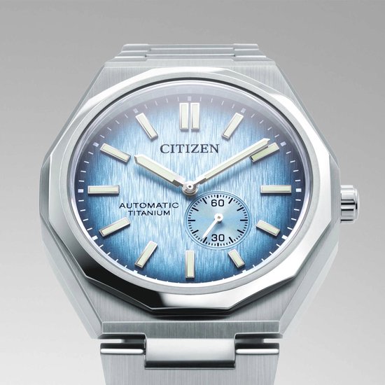Citizen horloge met een geometrische zilverkleurige titanium kast en band. Lichtblauwe wijzerplaat met geborstelde textuur en datumvenster.