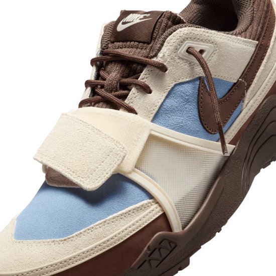 Close-up van de bruine, witte en lichtblauwe sneaker met klittenbandsluiting.