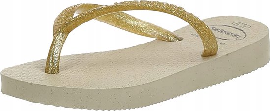 Lichtbruine Havaianas teenslippers met schuine gouden glitterbandjes.