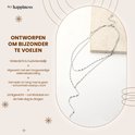 Gelaagde zilverkleurige ketting met fijne schakels en een Y-vormige drop, op een lichte achtergrond.