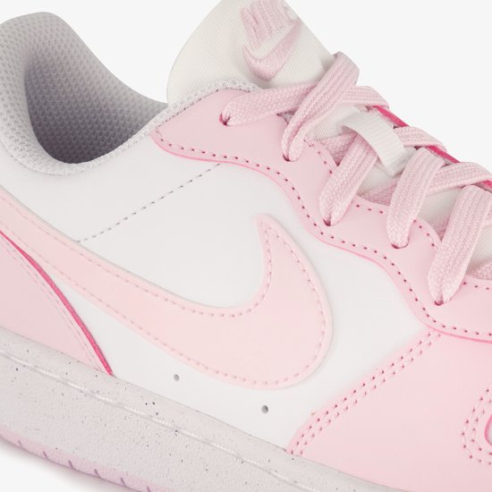 Wit leren sneaker met roze details en veters. Roze Nike-logo op de zijkant.