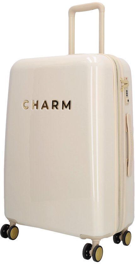 Crèmekleurige koffer met 'CHARM' in gouden letters, beige handvat en wieltjes.