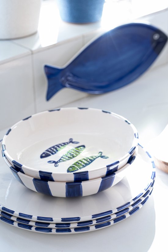 Wit keramiek met blauwe strepen en groen-blauwe visdecoratie. Drie vissen op de bodem.