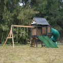 Speeltoestel met dubbele glijbaan, buisglijbaan en schommels in een grasveld.