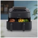 Zwarte Philips dubbele airfryer met lades vol met kip, aardappelen en sperziebonen.