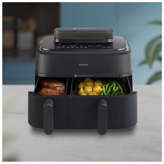 Zwarte Philips dubbele airfryer met lades vol met kip, aardappelen en sperziebonen.
