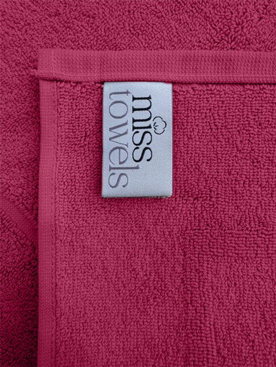 Close-up van de fuchsia badmat met het 'Miss Towels' label.