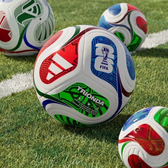 Voetbal met FIFA Wereldbeker logo en TRIONDA tekst. Rode, blauwe en groene patronen op witte vlakken.