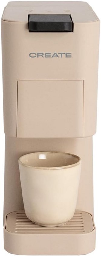 Beige koffiezetapparaat met de tekst 'CREATE' erop en een beige kopje onder de uitloop.