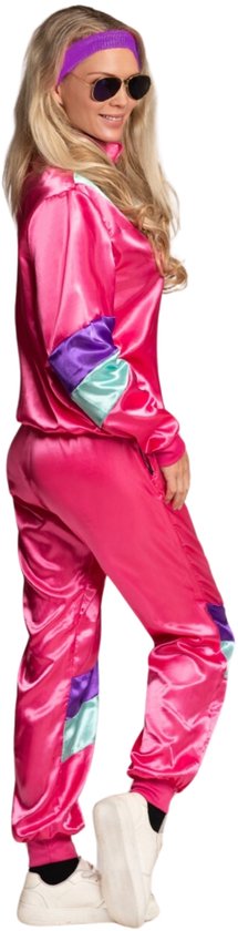 Vrouw in roze trainingspak, jaren 80 stijl, met paarse hoofdband en zonnebril.