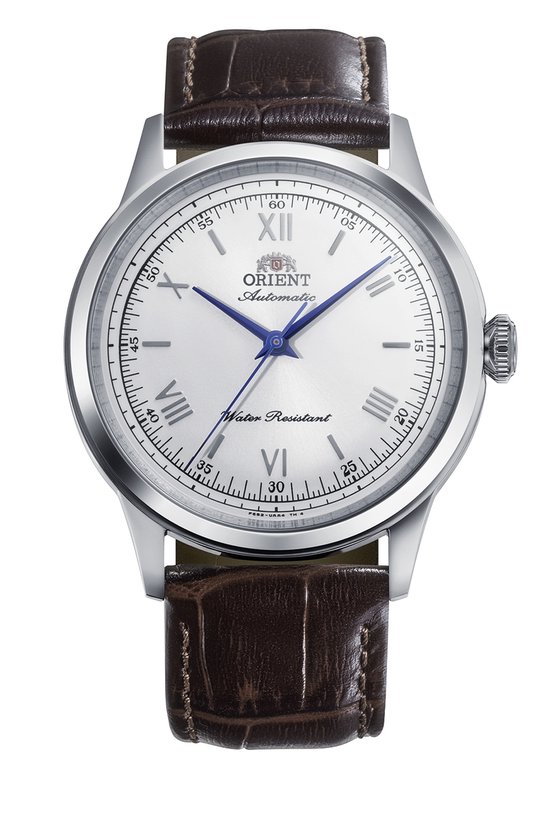 Zilverkleurig horloge met witte wijzerplaat, Romeinse cijfers, blauwe wijzers en bruine leren band.