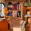 Gedetailleerd interieur van een miniatuur boekenwinkel met boekenplanken, een lamp en een kast.