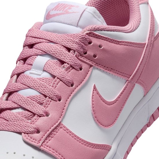 Detail van roze en witte Nike Dunk Low sneaker, voorkant met veters.