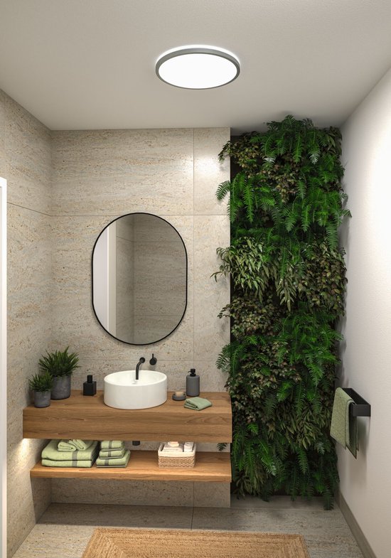 Rond LED paneel aan plafond in moderne badkamer met groene muur.