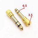 Twee gouden audiostekkeradapters, één met '6.5' en de ander met '3.5' aangeduid.