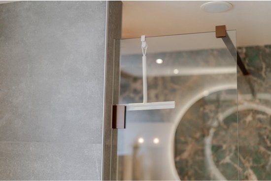 Crèmekleurige douchewisser met ophanglus, hangend aan een glazen douchewand.