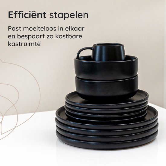 Stapel zwarte borden, kommen en mokken.