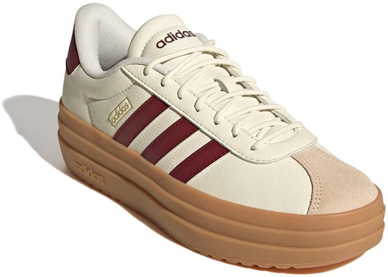 Crème lage sneaker met dikke bruine zool, bordeauxrode strepen, suède neus en Adidas logo.