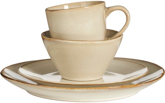 Een gestapeld beige servies: een bord, een kom en een mok, allemaal met een verweerde bruine rand.