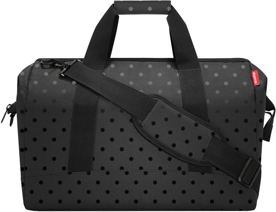 Zwarte weekendtas met glossy stippenprint en draagband.