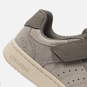 Close-up van de grijze Skechers sneaker met beige zool en klittenband.