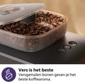 Kop met koffiebonen met een deksel met twee compartimenten.