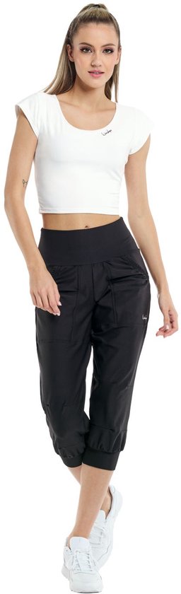Model in zwarte capribroek met wijde pijpen en witte crop top.