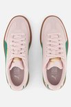 Bovenkant van twee roze Puma sneakers met bruine zolen en groene accenten.