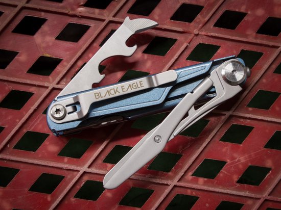 Blauwe multitool met mes, flesopener en schroevendraaier opengeklapt op rood rasteroppervlak.