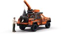Man laadt een olifant in een oranje pick-up truck met tijgerstrepen.