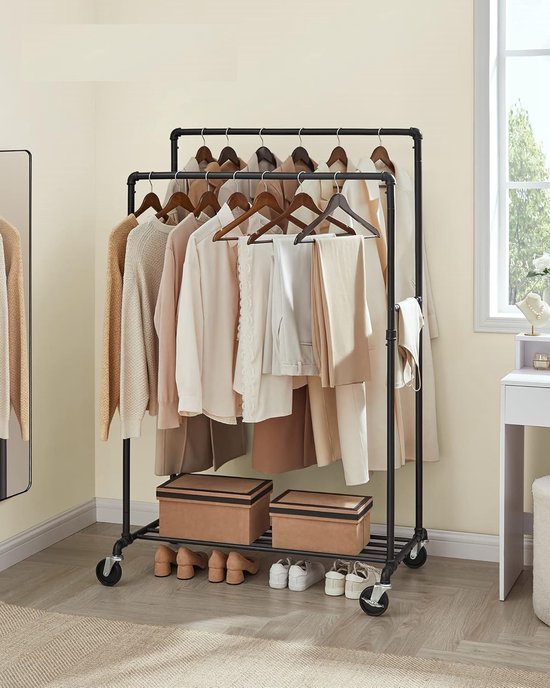 Kledingrek met dubbele stangen, gevuld met neutrale kleding, schoenen en dozen.