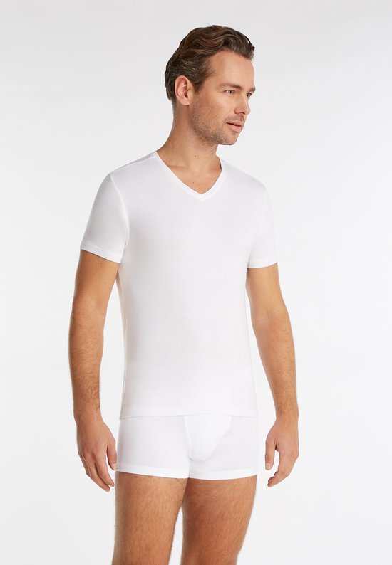Man met donker haar, zijkant, in wit V-hals shirt en witte boxershort.