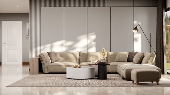 Lichtbeige stoffen hoekbank met veel kussens, een ronde witte salontafel en een zwarte bijzettafel met een vaas.