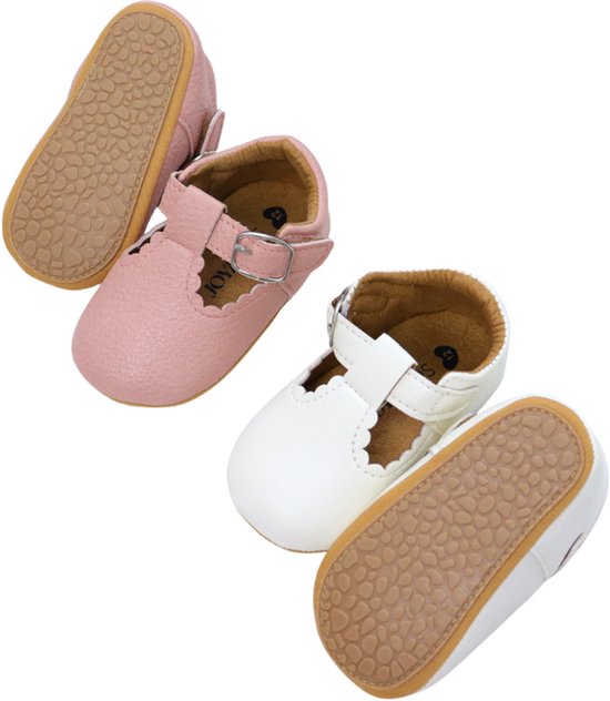 Paar roze babyschoentjes met gesp en witte schoentjes met gesp, beide met rubberen zolen.
