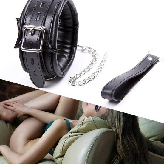 Zwarte, gewatteerde halsband met gesp en ketting, naast een leren handvat. Op de achtergrond een vrouw in blauwe lingerie op een bank.