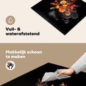 Zwarte inductiebeschermer met bloemenboeket, vuil- en waterafstotend en makkelijk schoon te maken.