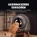 Grijze, ronde kattenbak met een grote opening waar een kat naar binnen kijkt. Oranje sensoren lijnen de ingang af.