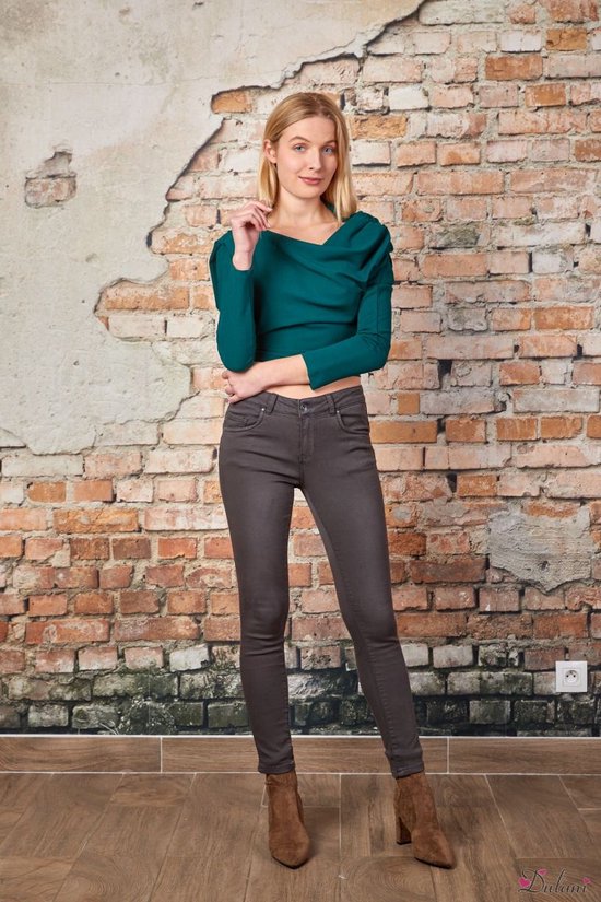 Modèle de face dans un pantalon push-up gris et un haut vert foncé tendance.