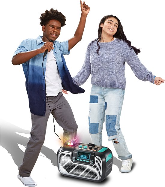 Jonge man met microfoon en dansende jonge vrouw bij zwarte VTech Super Sound Karaoke speaker met discobol.
