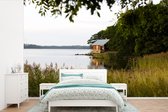 Behang - Fotobehang huis aan een meer in Finland - Breedte 450 cm x hoogte 300 cm