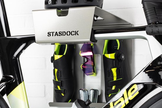 Zilverkleurig Stasdock-rek met zwarte racefietsschoenen, racefietsbril en CO2-patronen, op een racefiets.