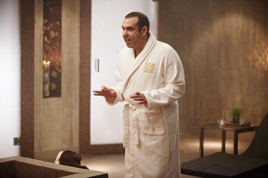 Man in wit badjas in een spa, praat met zijn handen.