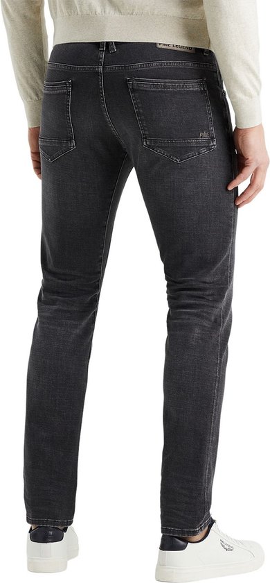 Man met grijze jeans en witte sneakers
